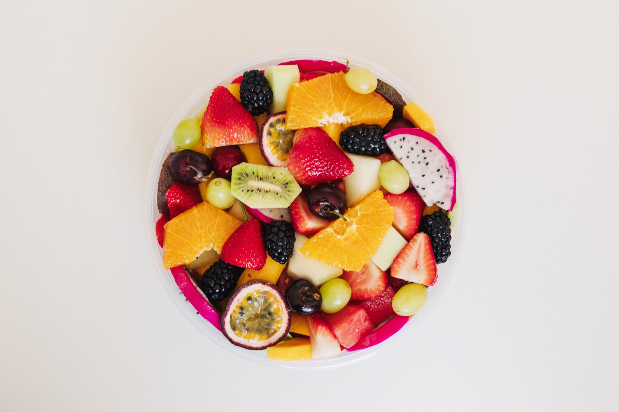 Fresh fruit salad tub from Top Fruit Market Greenacre Sydney with seasonal fruit including melon, pineapple, grapes, berries, and mango.